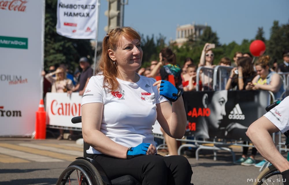 Люди с ограниченными возможностями здоровья, пользующиеся инвалидной коляской, участвуют в благотворительном забеге